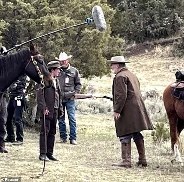 Alec Baldwin is seen on Friday on the set of his Western film Rust, which resumed filming following the October 2021 death of a camerawoman. Baldwin is seen handing a prop gun to another crew member, holding it by the barrel