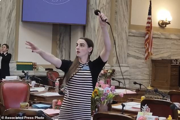 Montana Democratic Rep. Zooey Zephyr hoists a microphone into the air on Monday as her supporters interrupt proceedings in the state House by chanting 'Let Her Speak!'